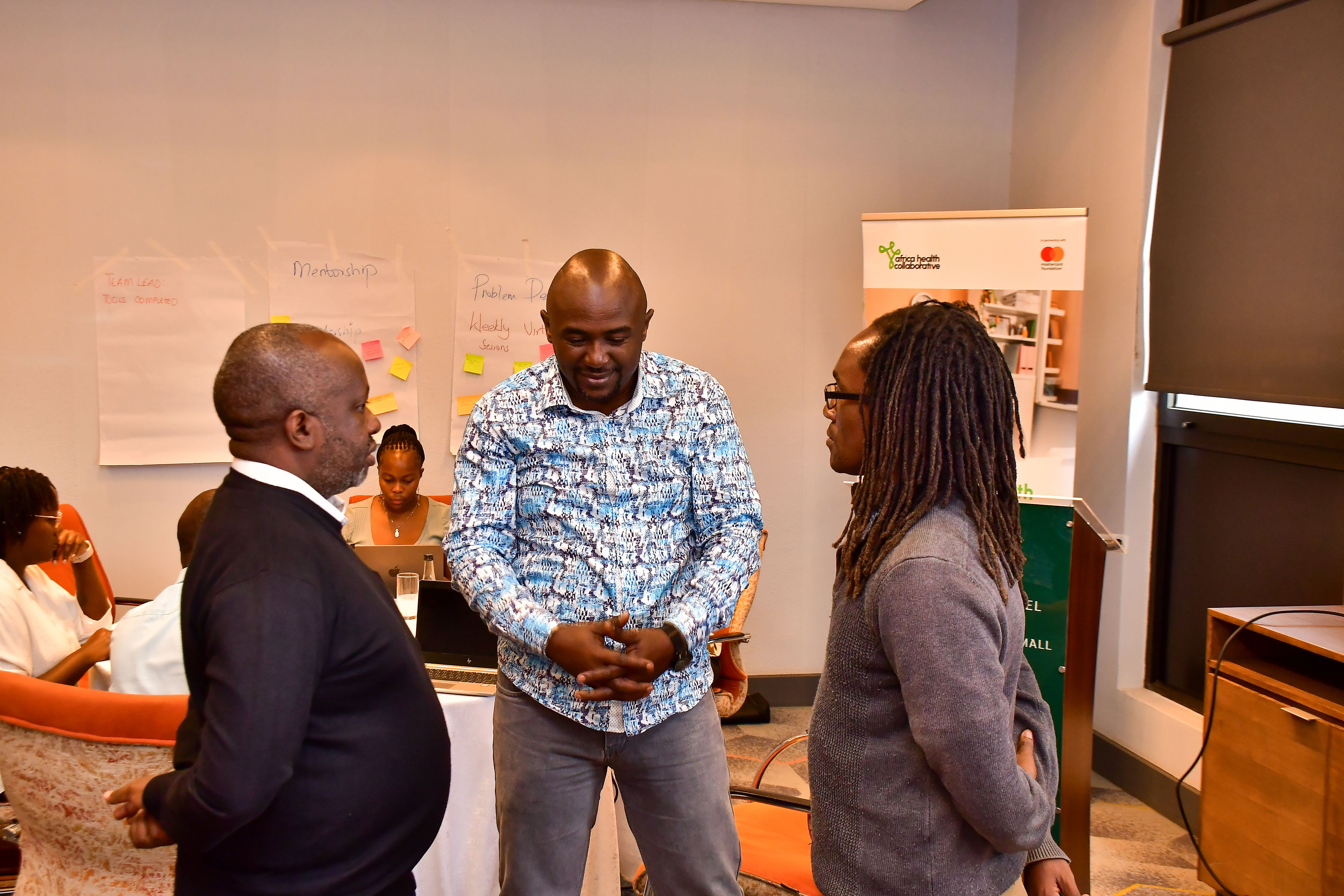 A side conversation with colleagues during the AfyaVentures Workshop at Holiday Inn by IHG, Two Rivers, Nairobi.